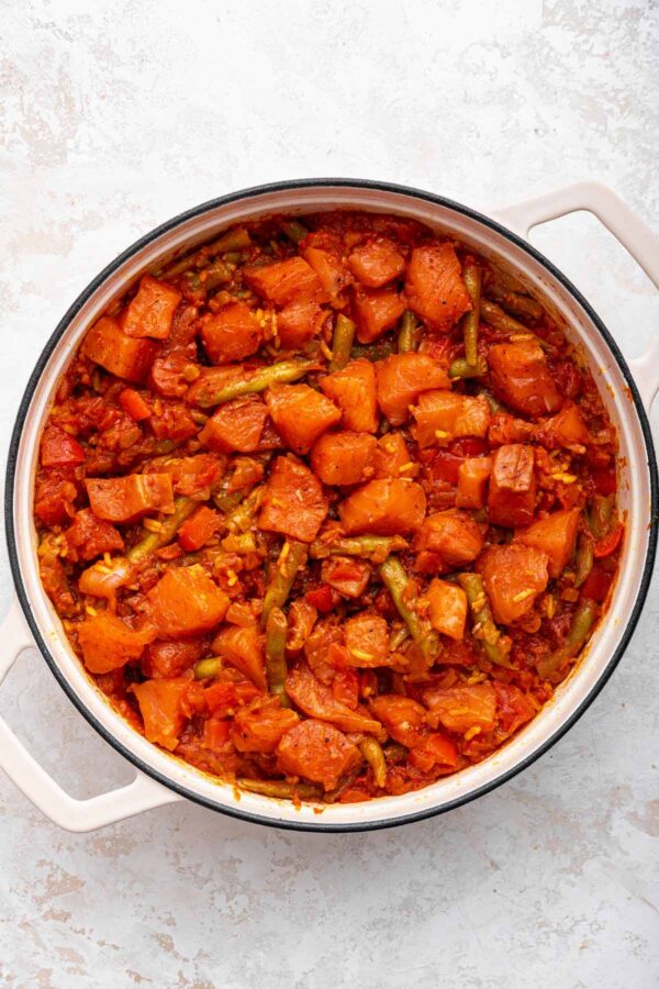 salmon pieces sitting on top of homemde paella. 