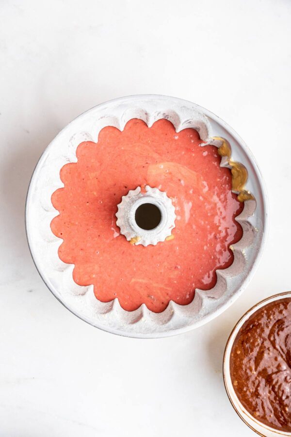 layer of strawberry cake batter in a bundt pan.