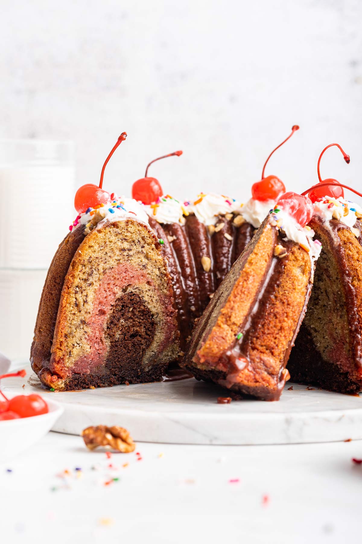 side view of a banana split bundt cake with a few slices removed.