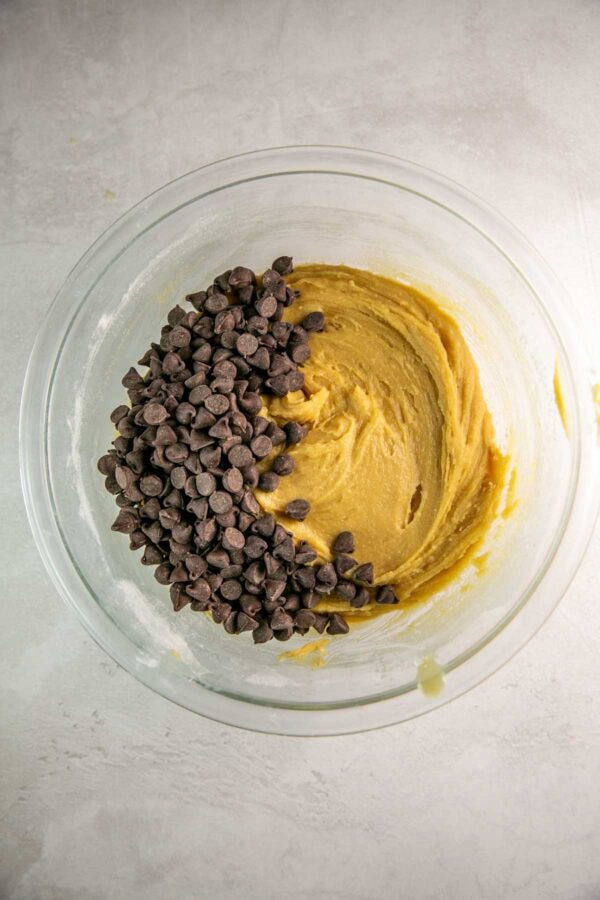 cookie bar dough with a pile of chocolate chips on top.