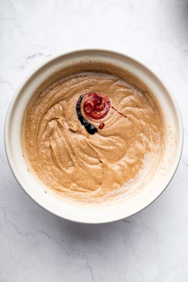 red velvet cake batter with a drizzle of red food coloring on top.
