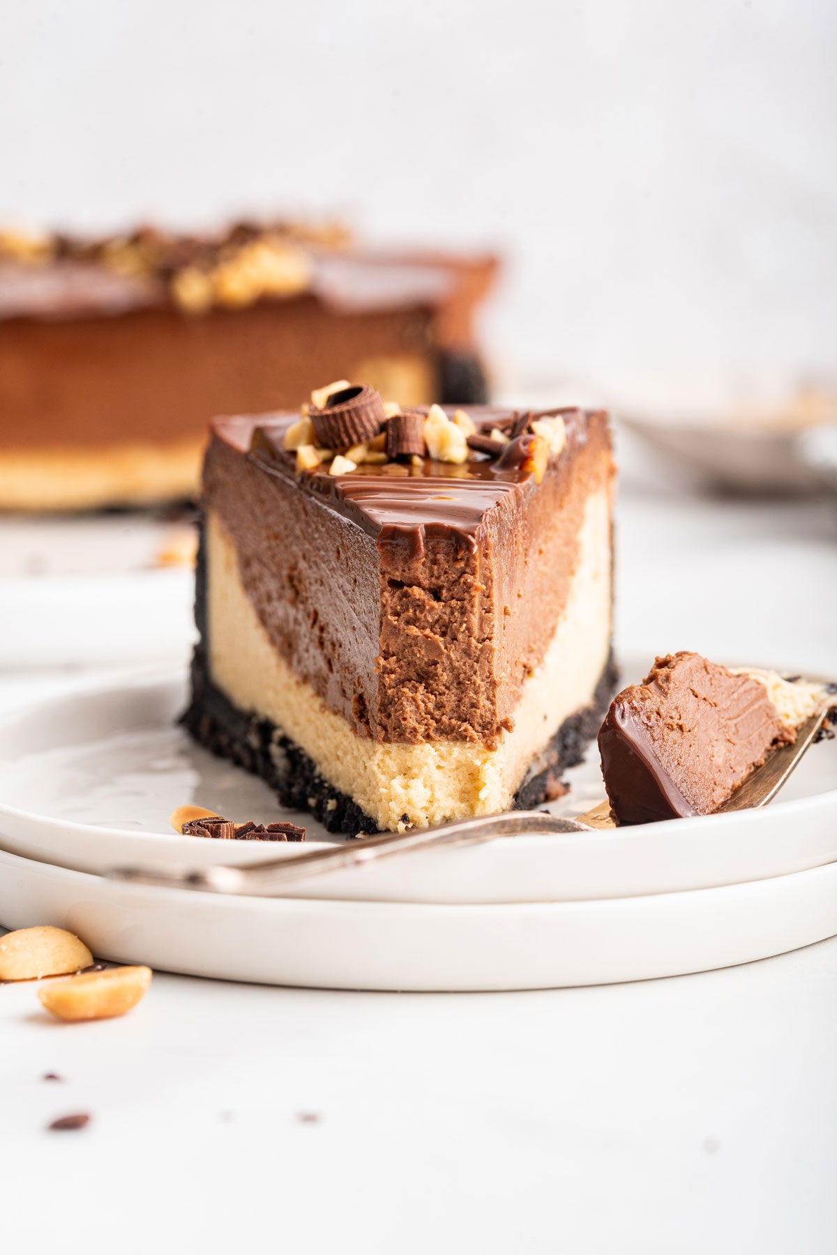 slice of peanut butter chocolate cheesecake with a forkful removed.