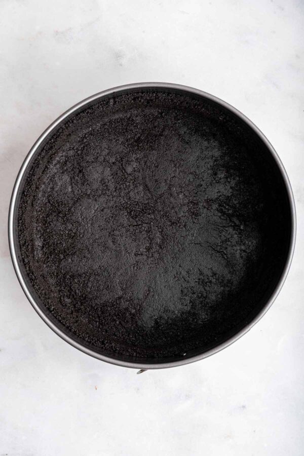 oreo cookie crust pressed into a springform pan.