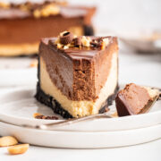 slice of chocolate peanut butter cheesecake with a forkful removed.