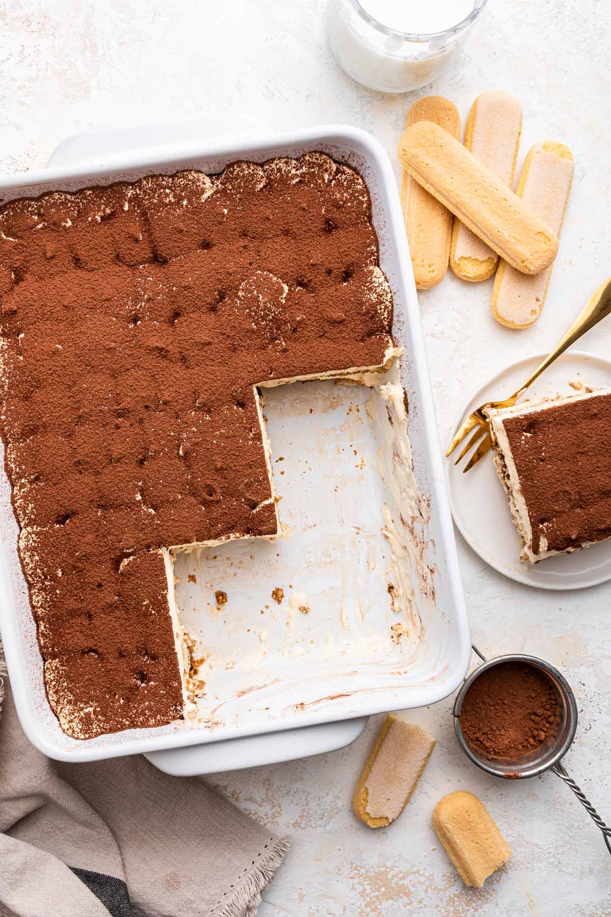 large pan of tiramisu with a few slices removed.