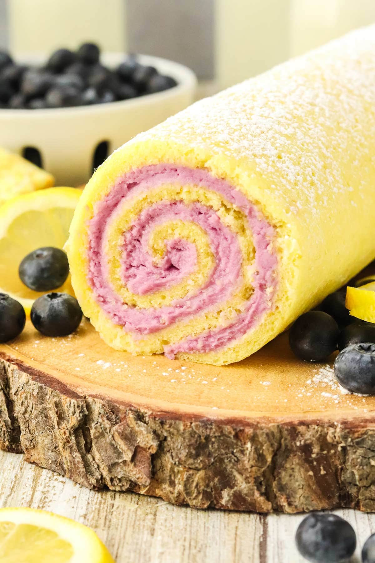 lemon cake roll filled with swirls of purple cream cheese blueberry fillng.