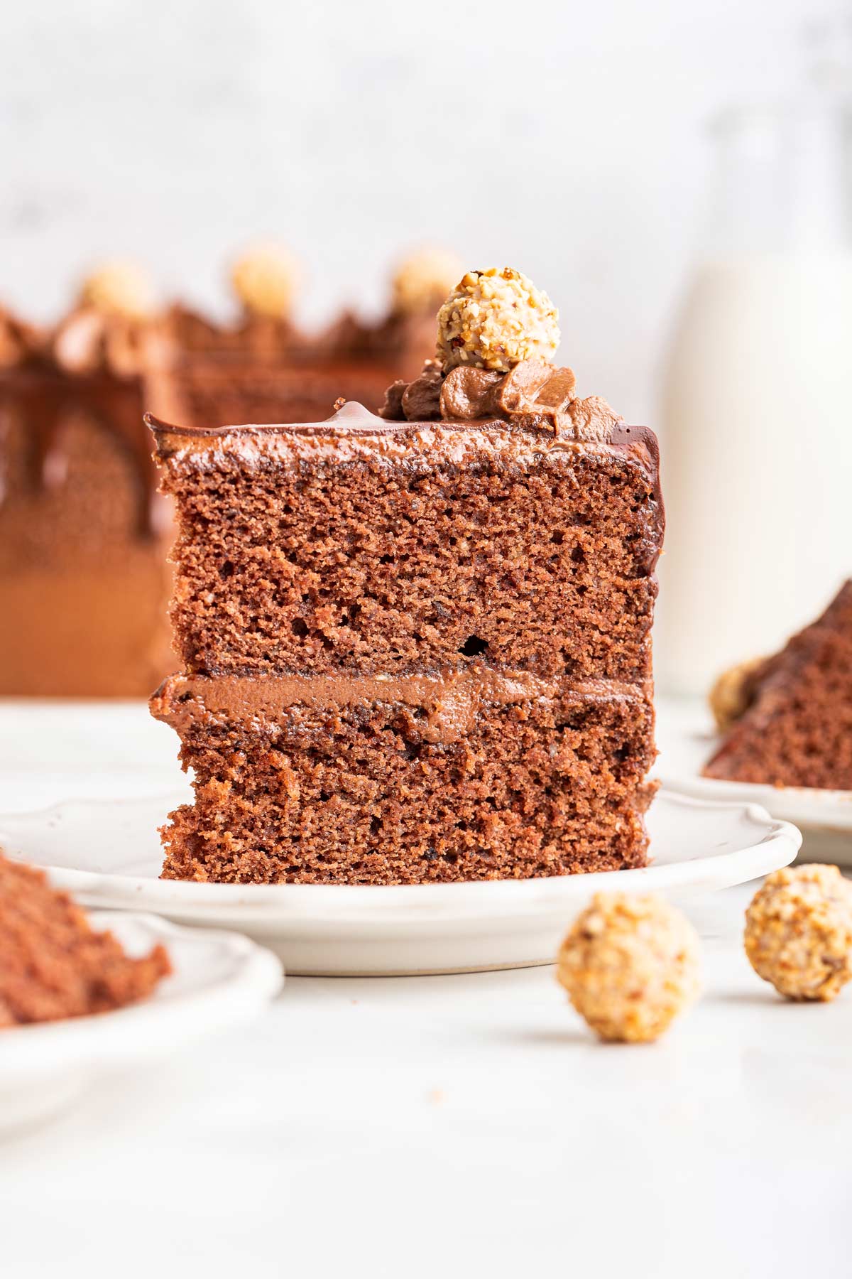 slice of two layer chocolate hazelnut cake on a dessert plate.