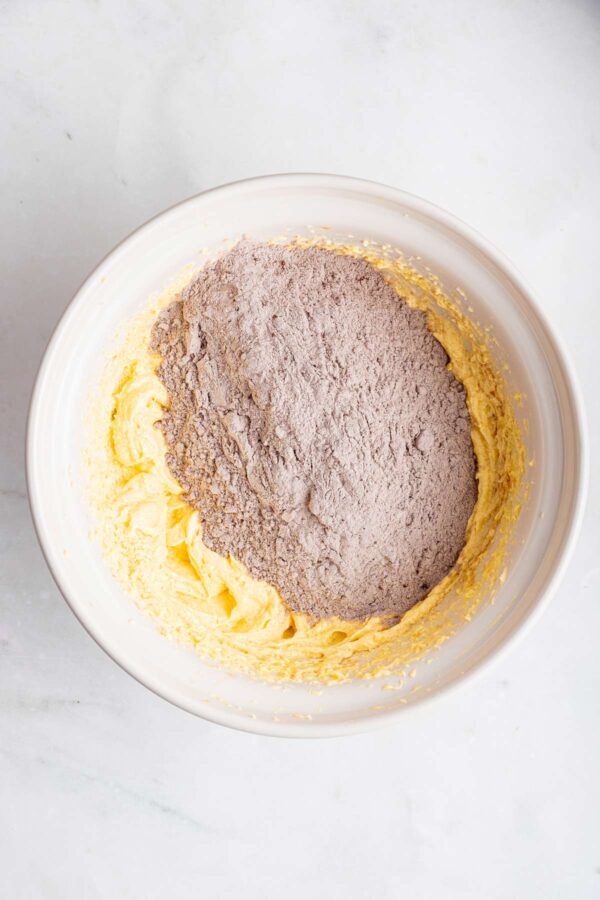 adding flour and cocoa powder to whipped eggs and butter.