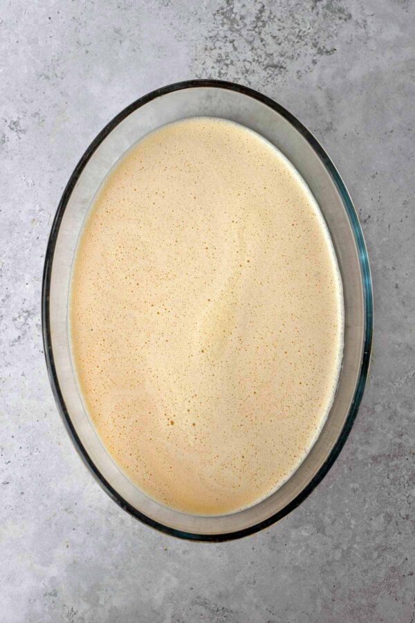 clafoutis batter poured into a glass baking dish.