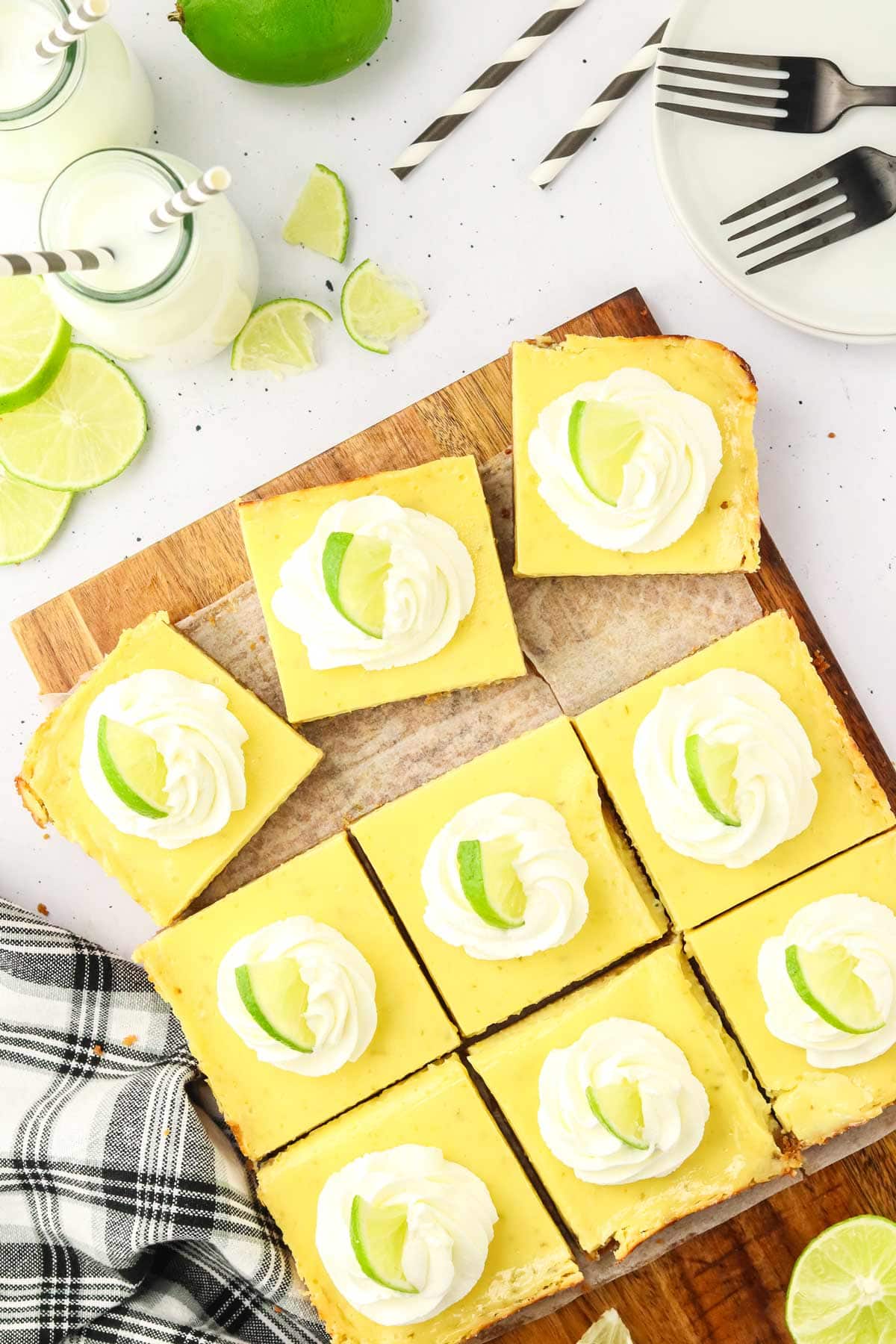 key lime pie bars with a graham cracker crust decorated with whipped cream.