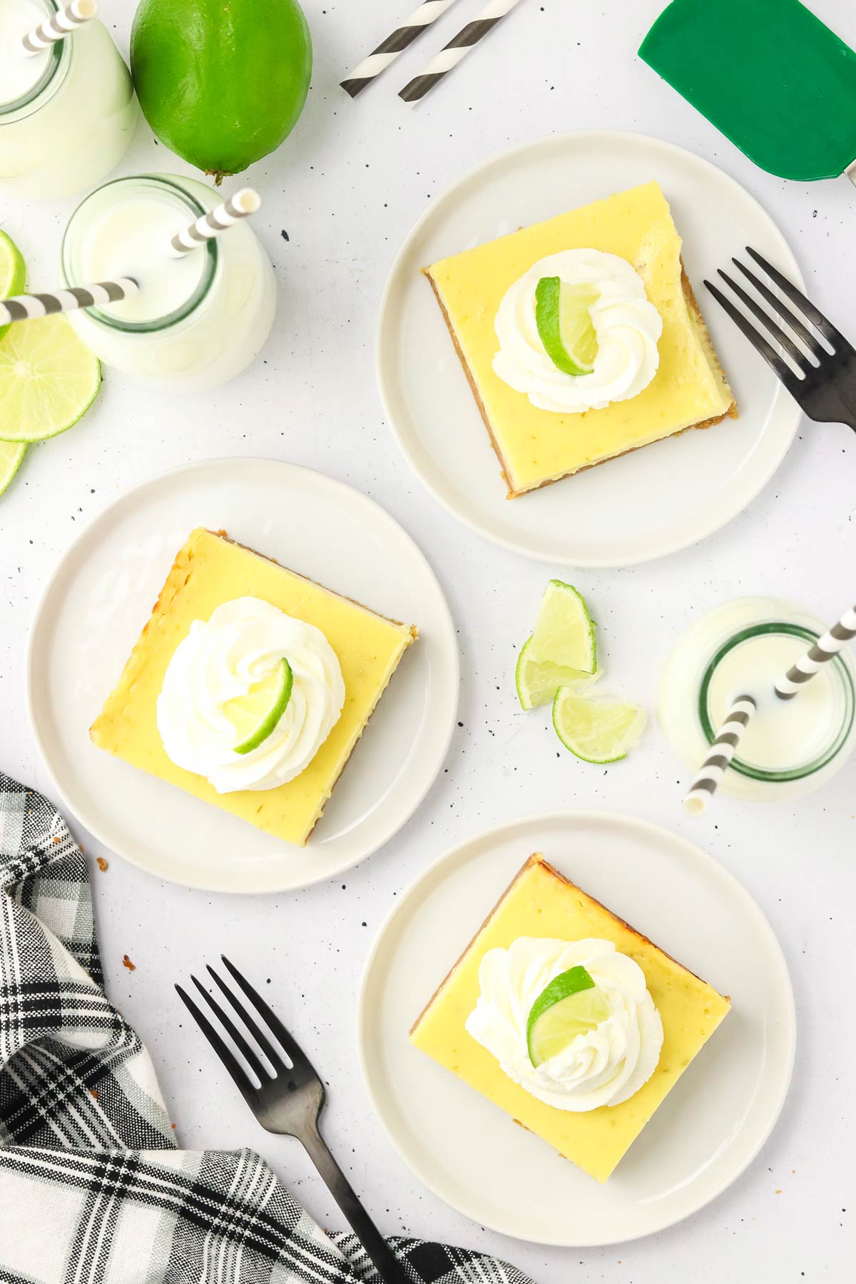 three key lime pie bars on small dessert plates.