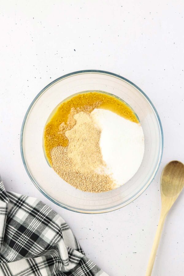 graham cracker crumbs, melted butter, and sugar in a glass mixing bowl.