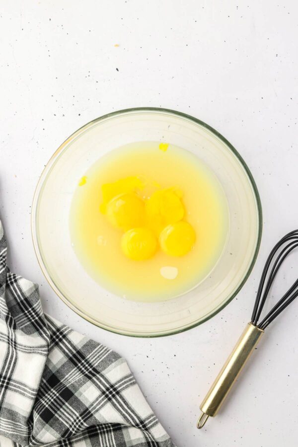 eggs, lime juice, and condensed milk in a glass mixing bowl.