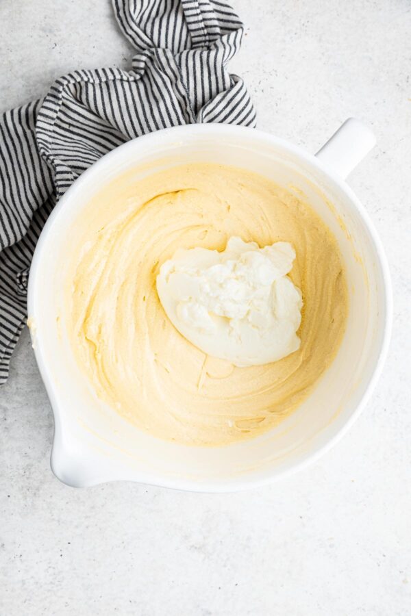 stirring sour cream into vanilla cake batter.