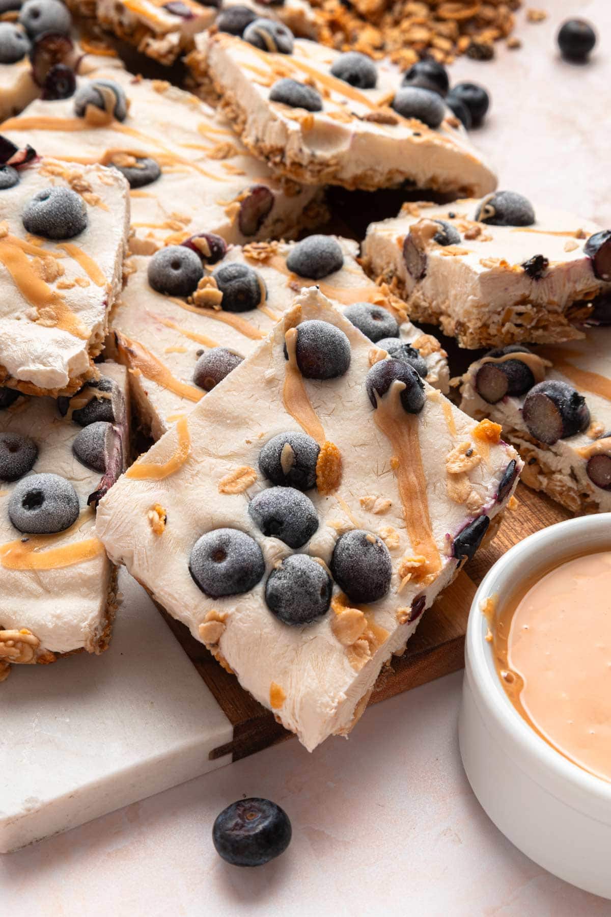 frozen yogurt bars next to a small bowl of peanut butter.