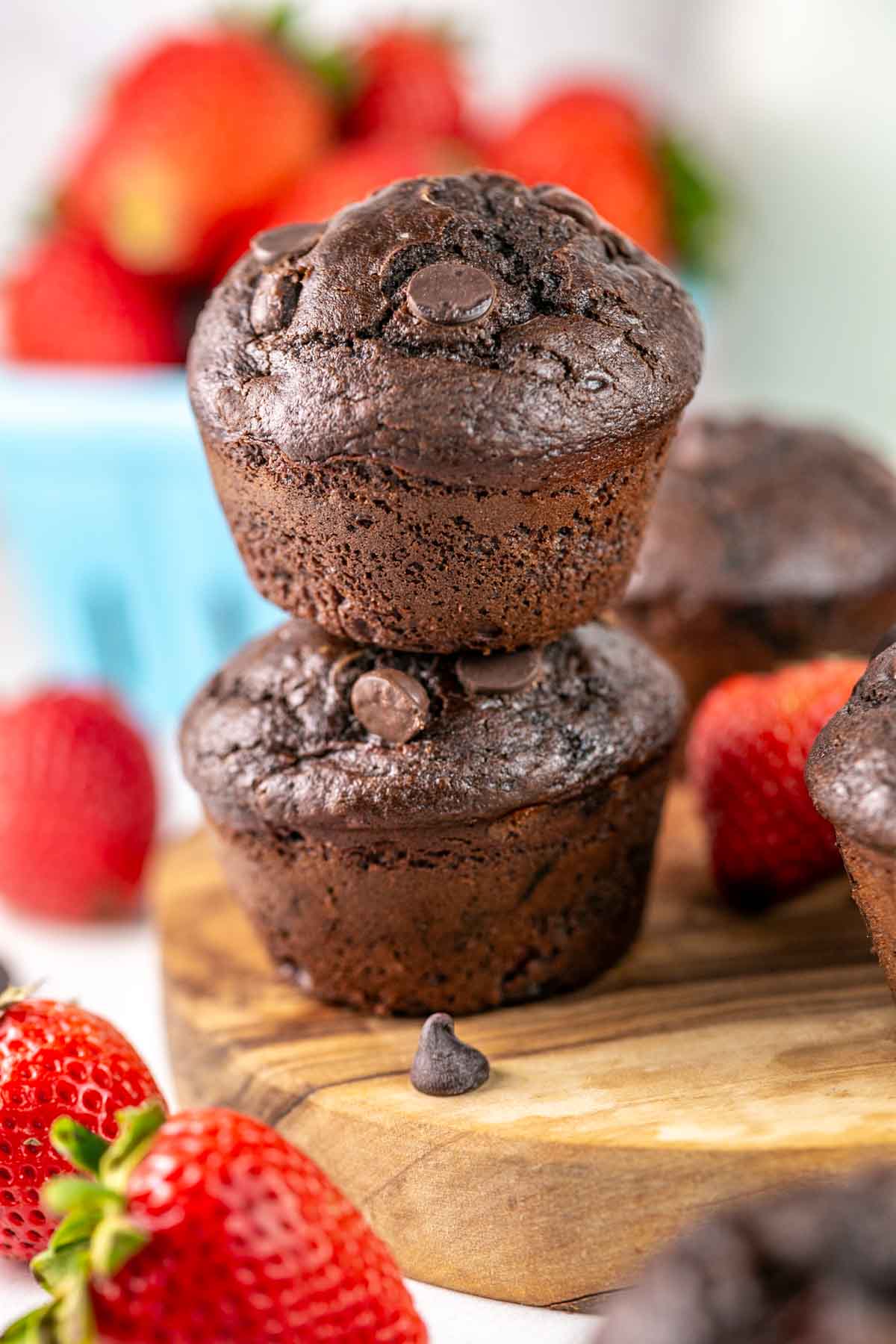 two chocolate strawberry muffins stacked on top of each other.