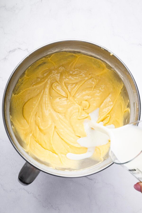 pouring milk into cake batter.
