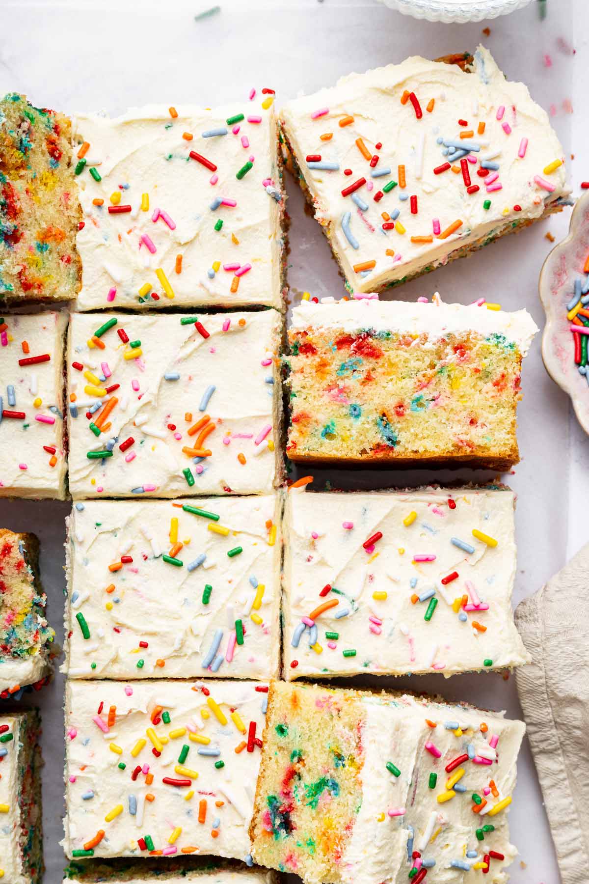 slices of funfetti sheet cake covered with vanilla buttercream frosting.