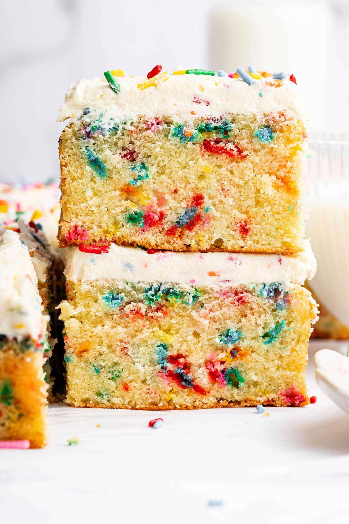 two slices of funfetti sheet cake stacked on top of each other.