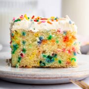 A slice of funfetti sheet cake with sprinkles on top.