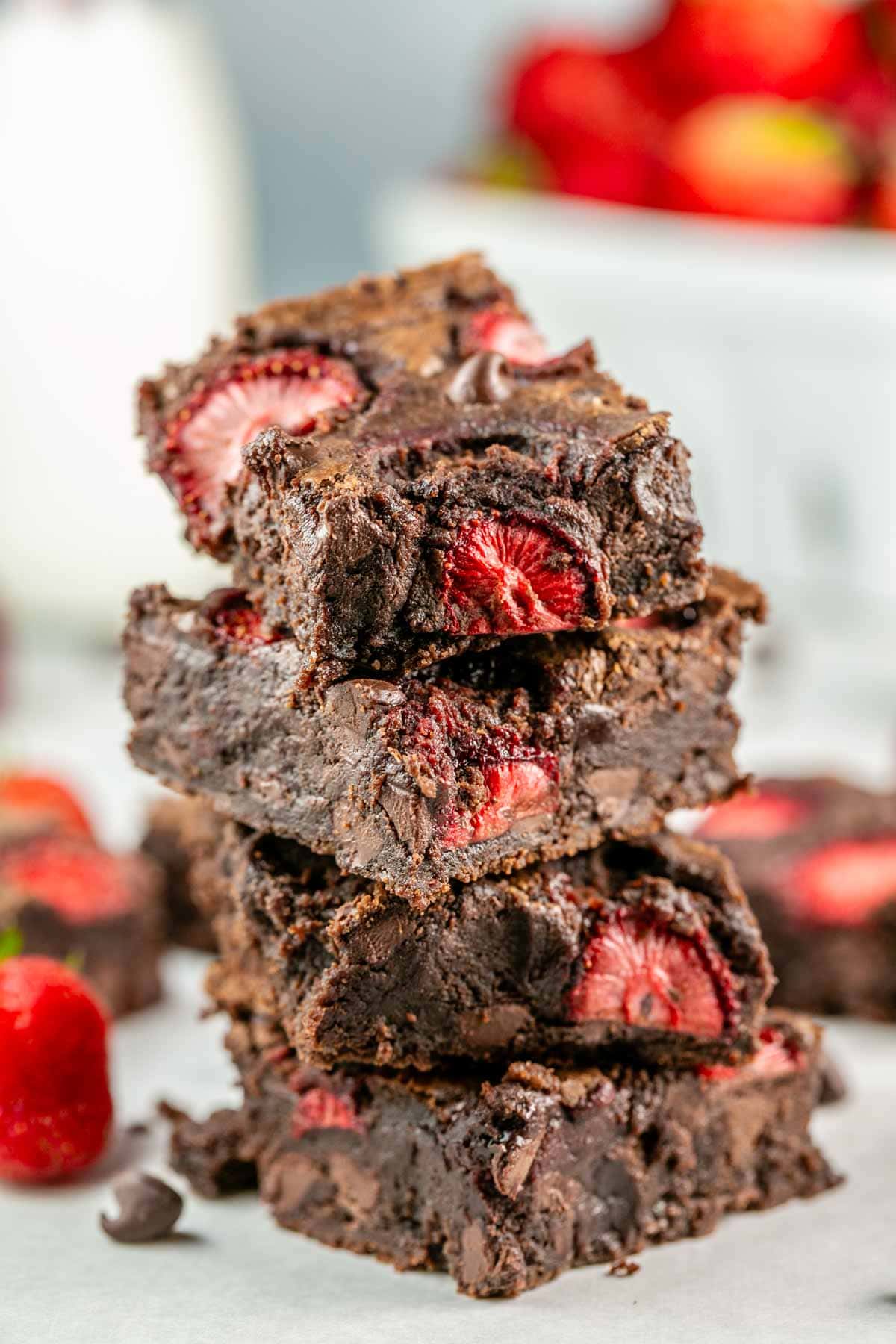 stack of four brownies showing the fudgy interior and pockets of strawberry jam.