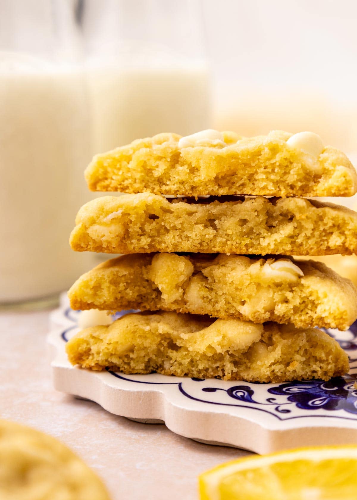 stack of lemon cookies cut in half showing the soft interior and white chocolate chips.