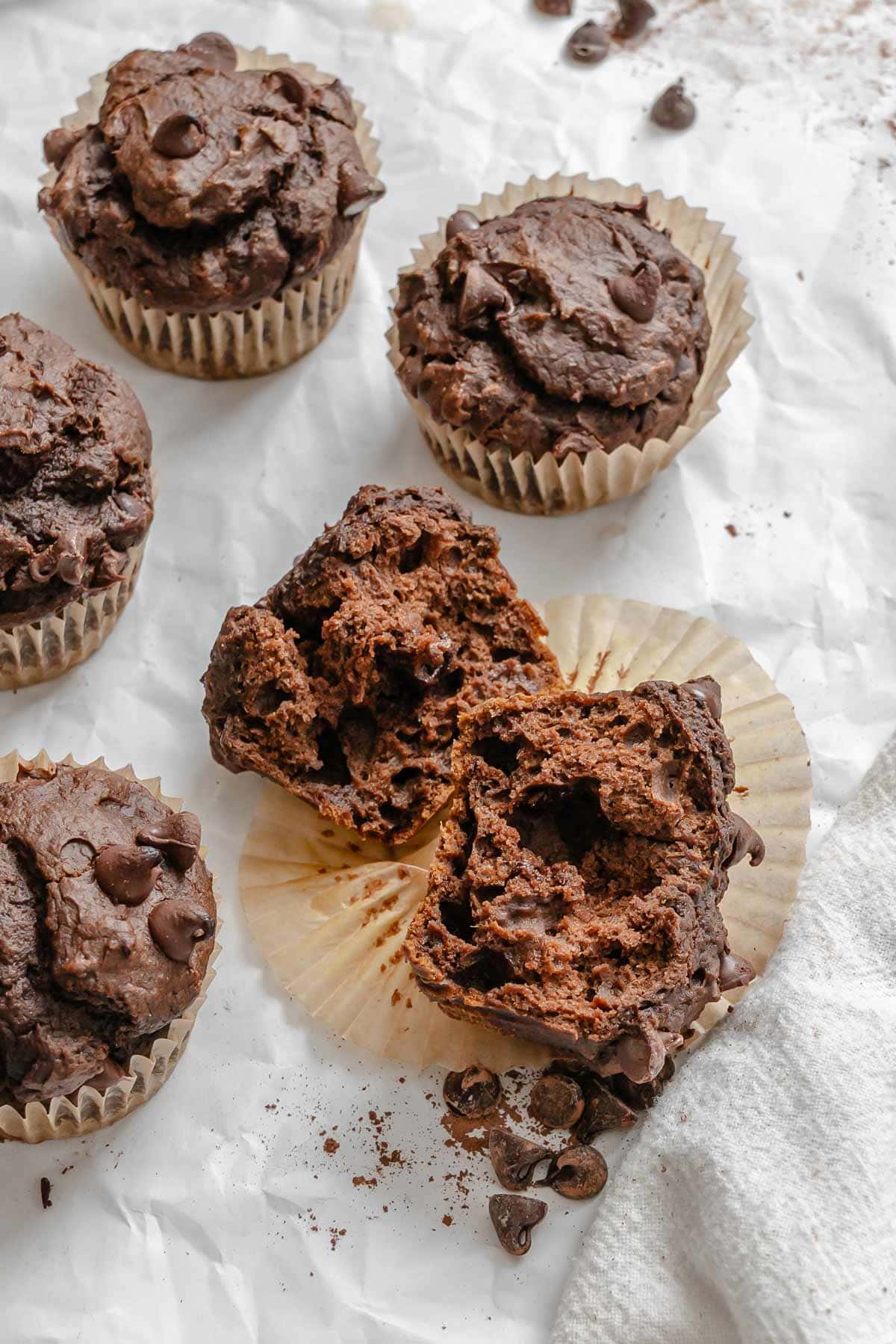 chocolate pumpkin muffin cut open showing the fluffy interior.