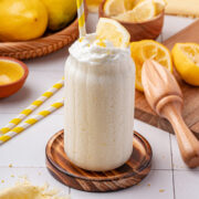 glass filled with creamy frozen lemonade topped with a dollop of whipped cream.