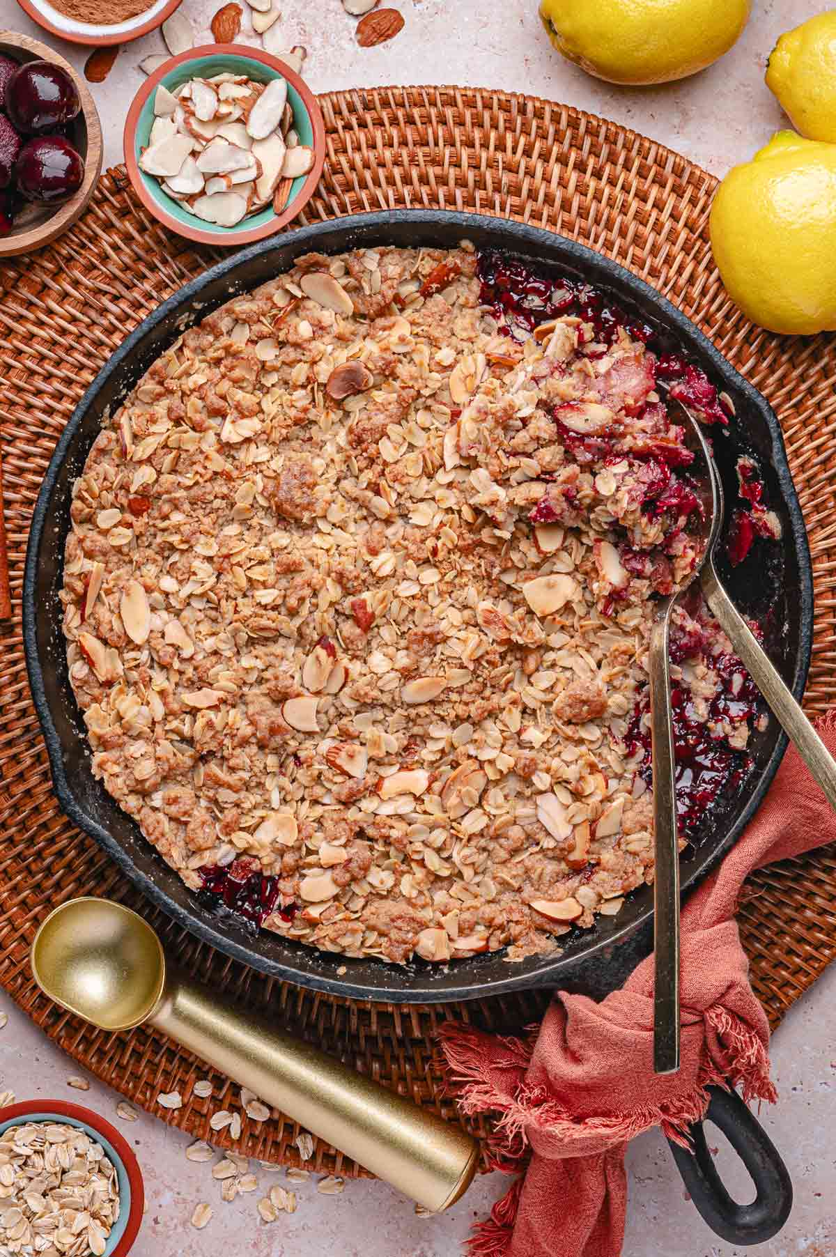 peach cherry crisp with a golden brown top in a cast iron skillet.