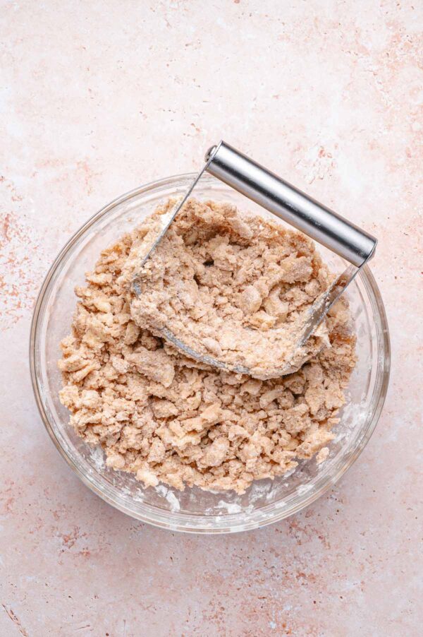 cutting butter into a flour mixture using a pastry cutter.