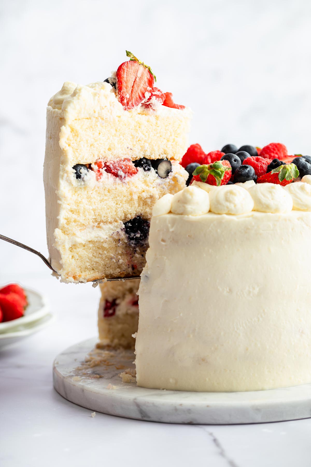 fluffy white cake with chantilly frosting covered with fresh berries.