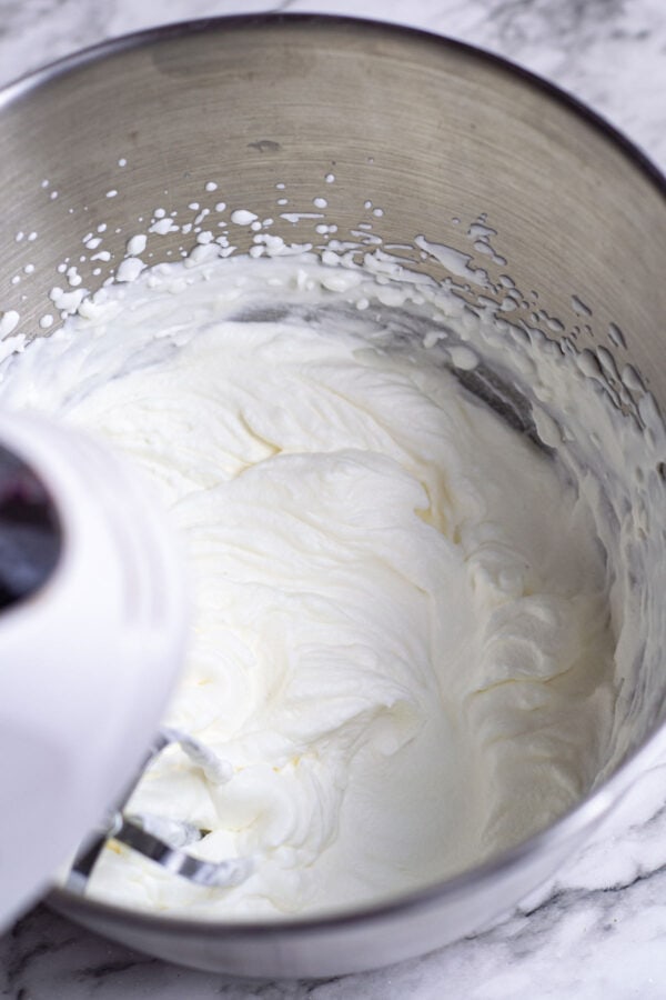 whipping heavy cream with a hand mixer.