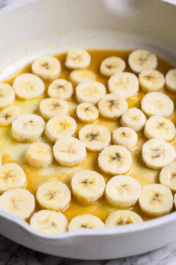 slices of fresh bananas cooking in a pan.
