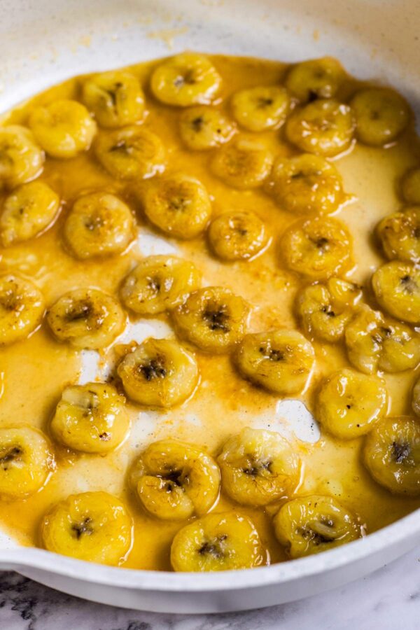 caramelized bananas in a pan with a layer of caramelized sugar.