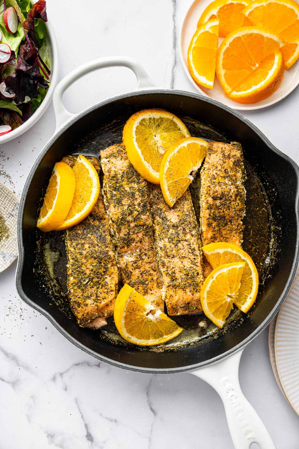 herby citrus salmon in a saute pan.