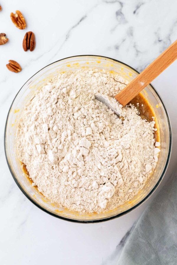 folding flour into the batter for an applesauce cake.