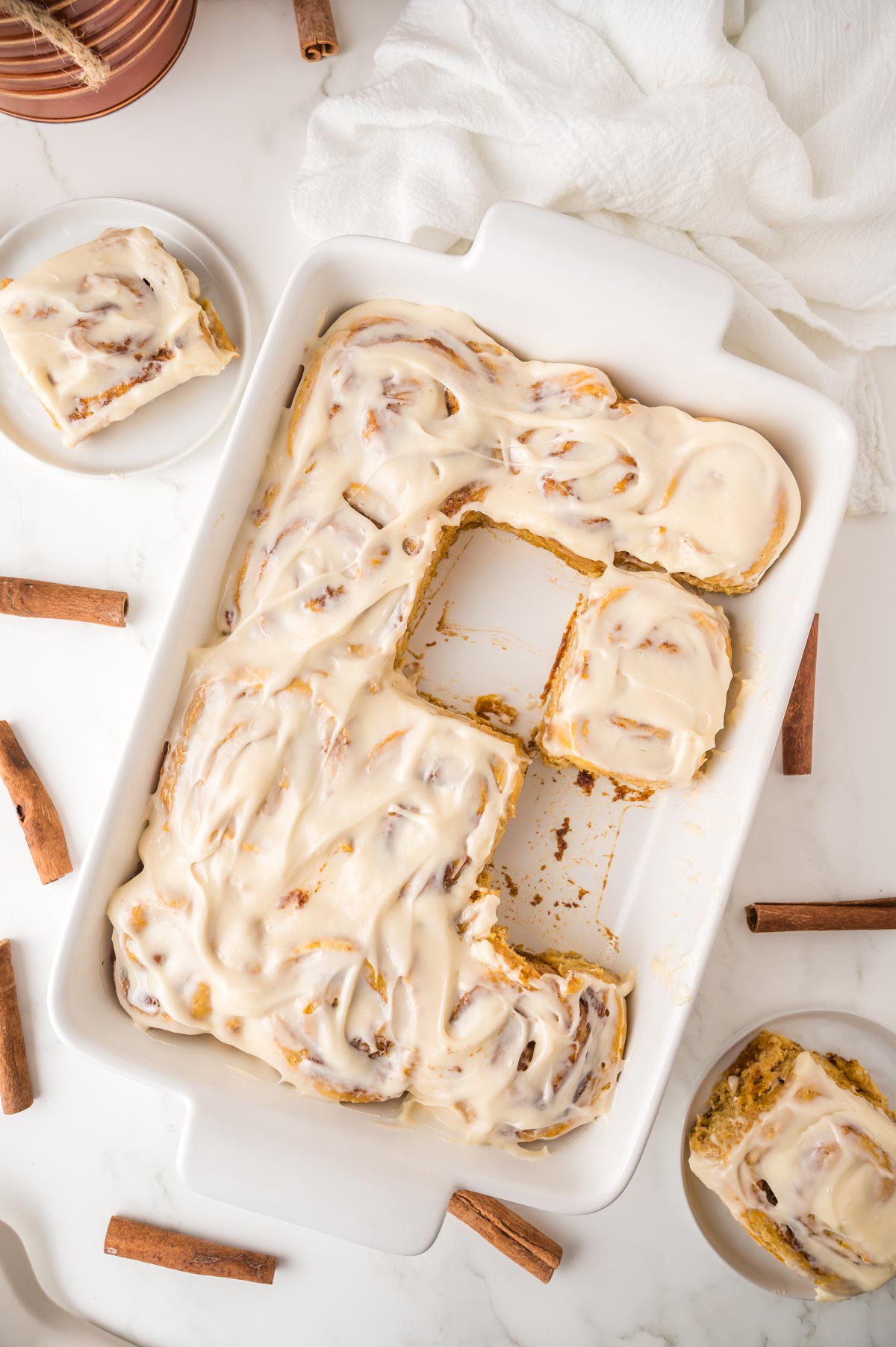 pan filled with pumpkin cinnamon rolls with gooey cream cheese frosting.