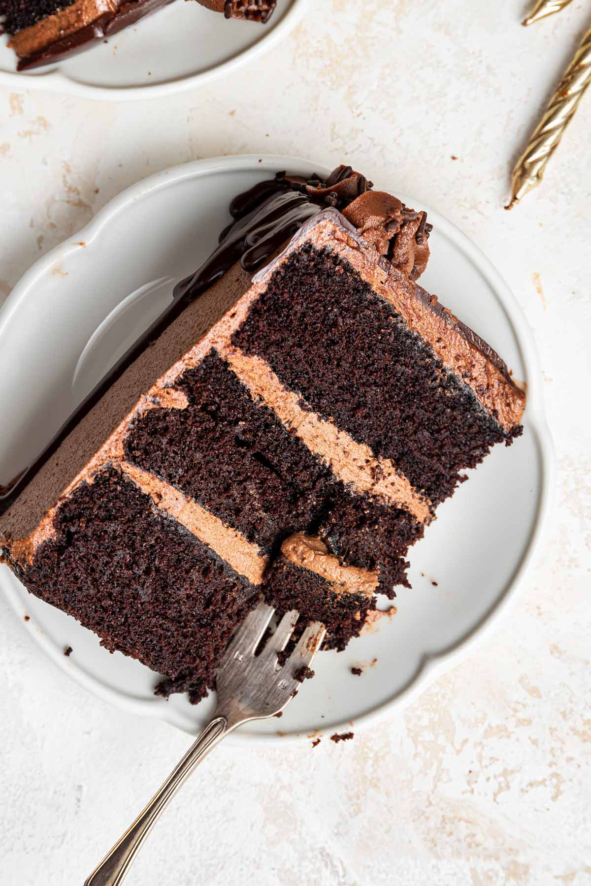 slice of three layer cake with thick layers of american-style buttercream.