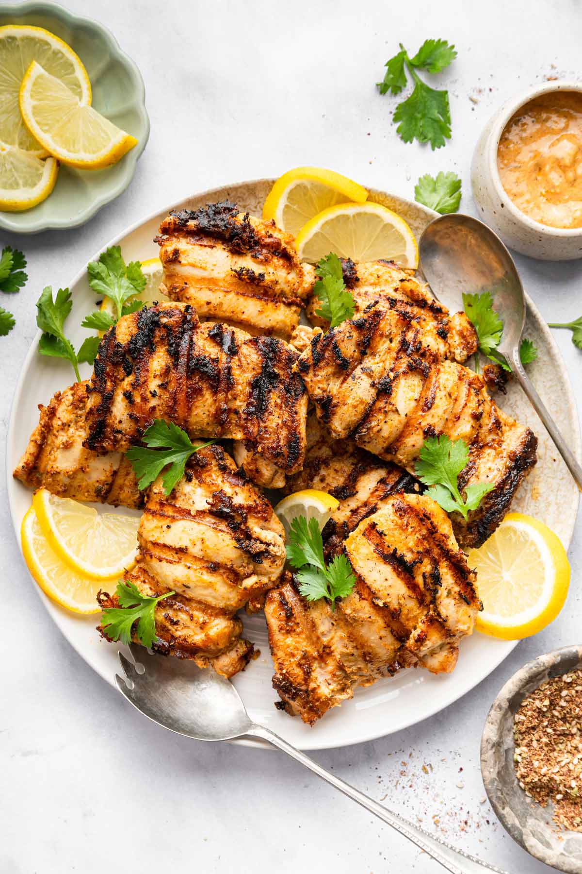 serving plate filled with grilled chicken with a garlicky tahini sauce.