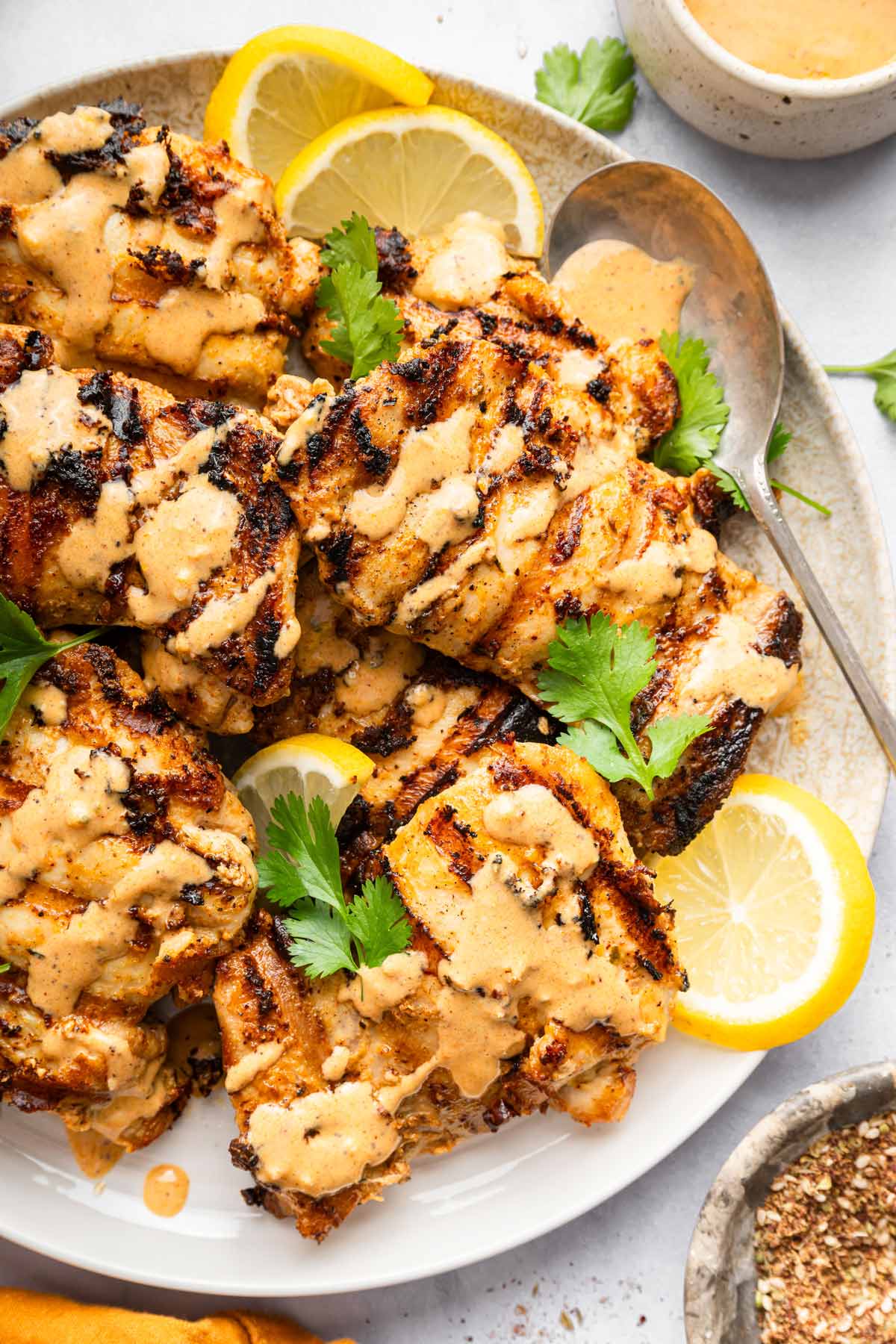 grilled tahini chicken with a garlic tahini sauce and fresh lemons.