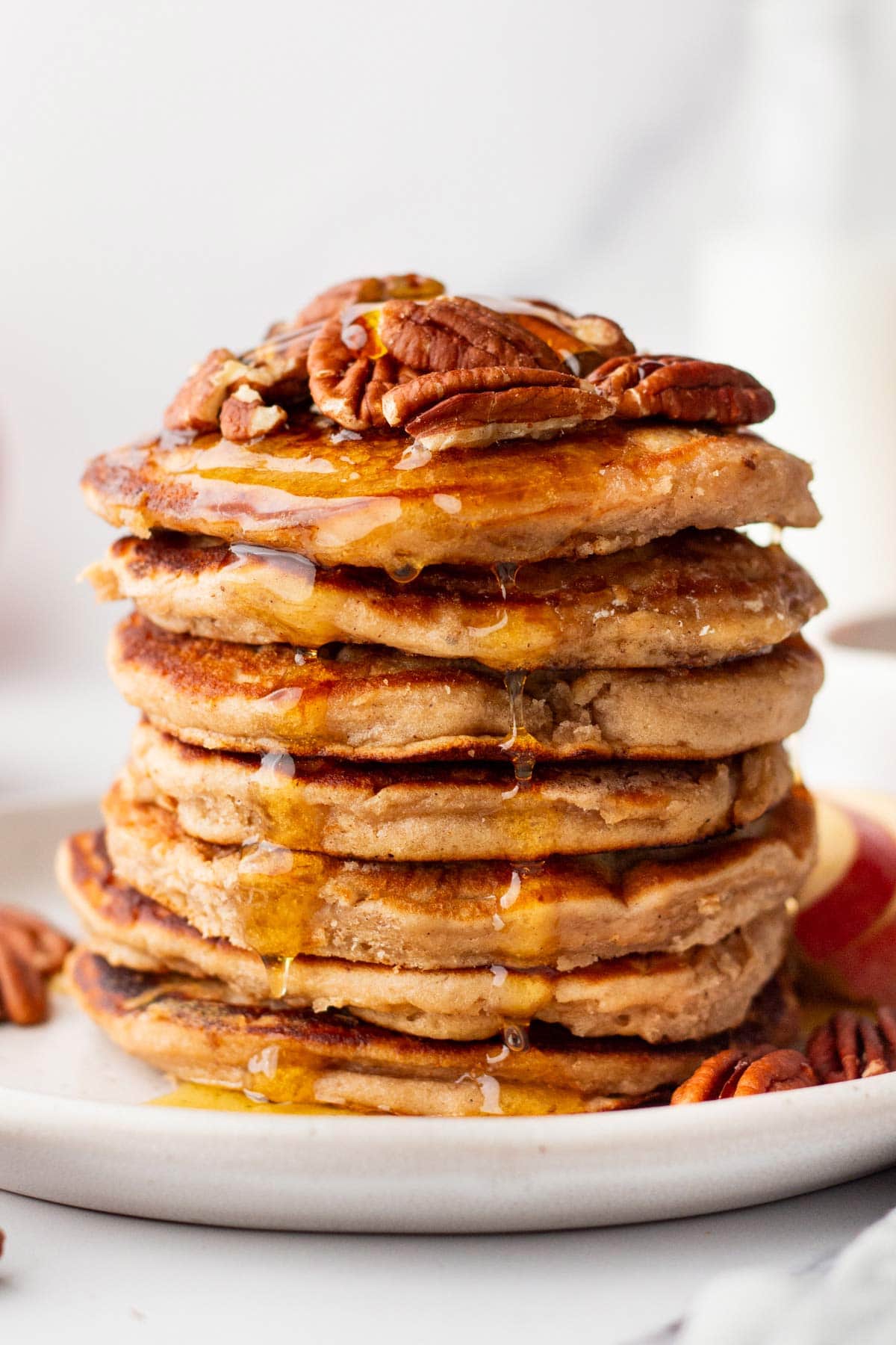 tall stack of apple butter pancakes covered with tosted pecans.