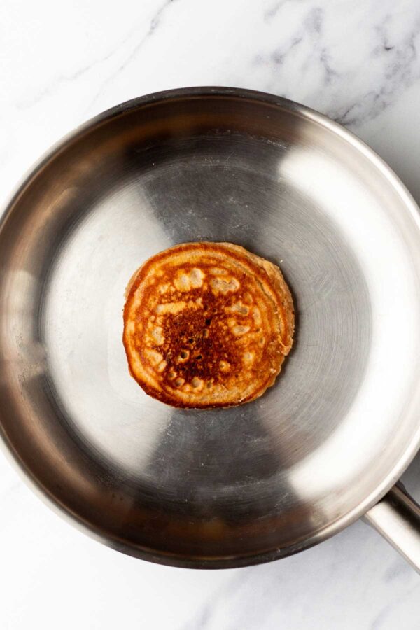 cooking apple butter pancakes in a skillet.
