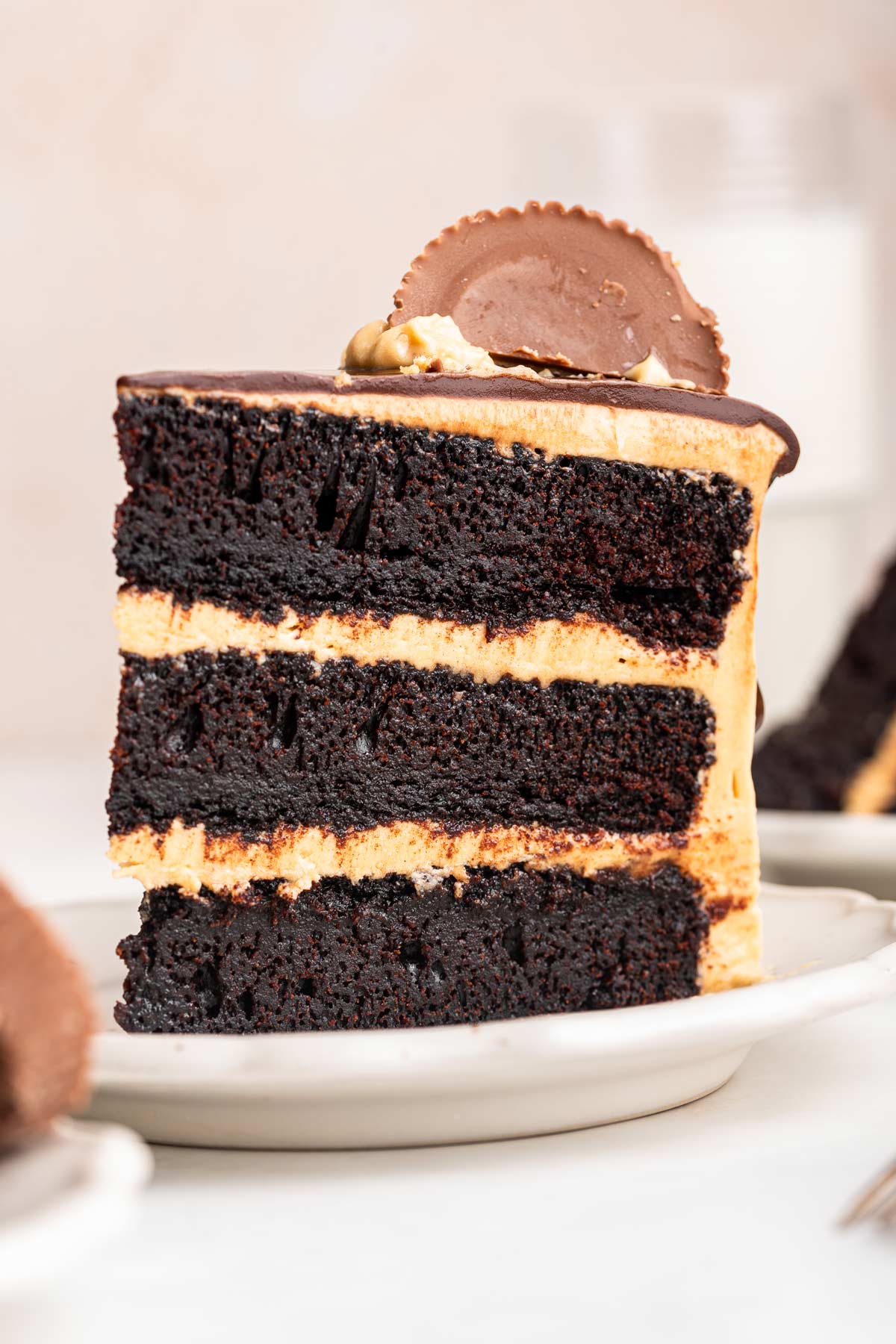 slice of chocolate peanut butter cup cake on a dessert plate.