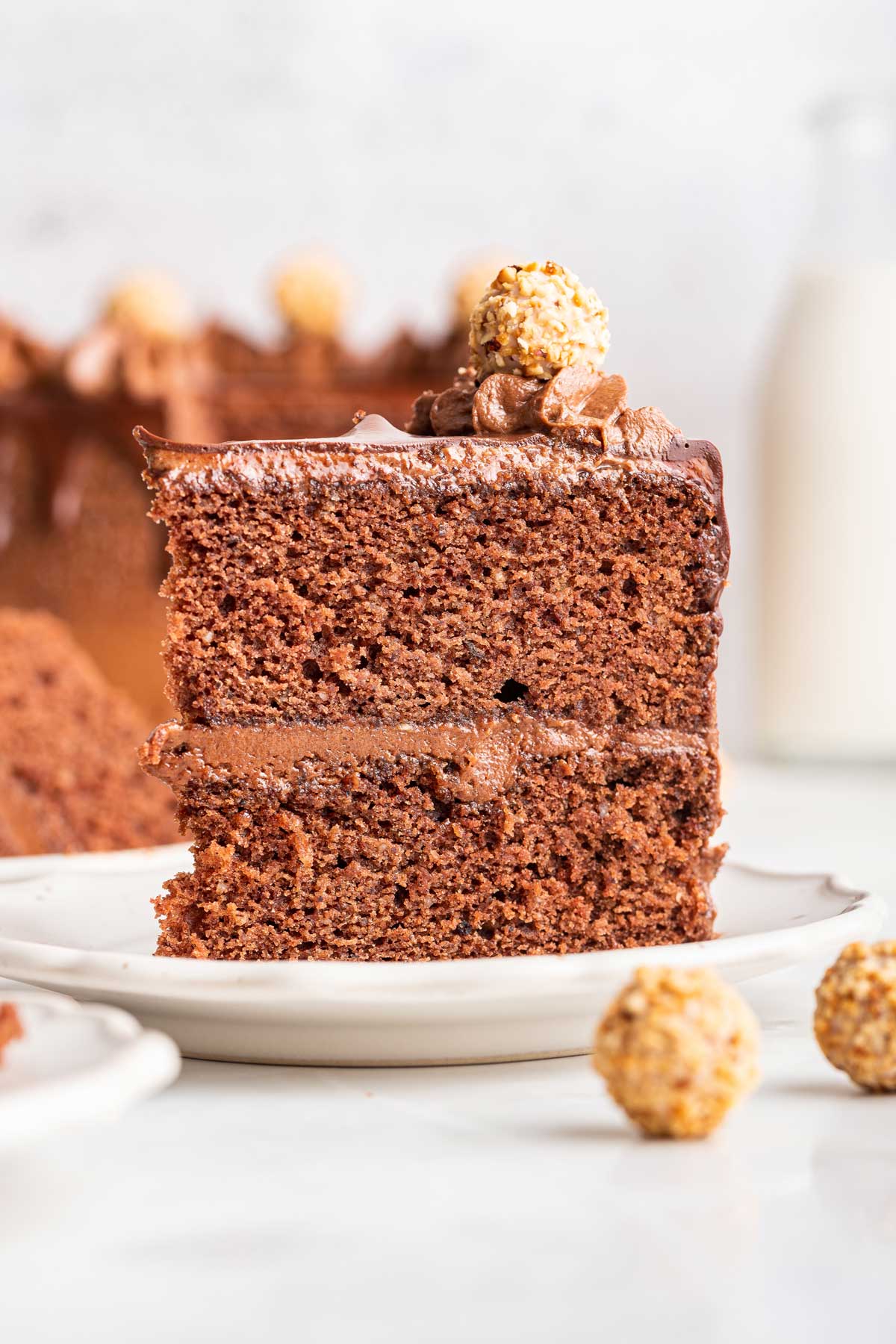 slice of chocolate cake showing the thick layer of smooth nutella frosting.