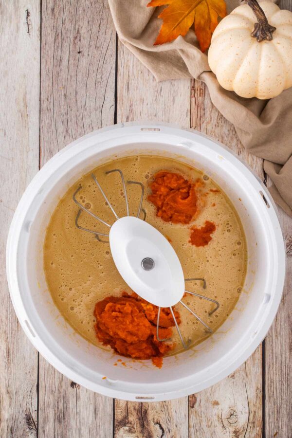 adding pumpkin puree to cake batter.