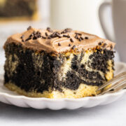 slice of marble sheet cake with chocolate frosting on a dessert plate.