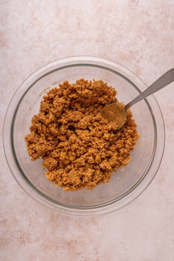 graham cracker crumbs and melted butter in a glass bowl.
