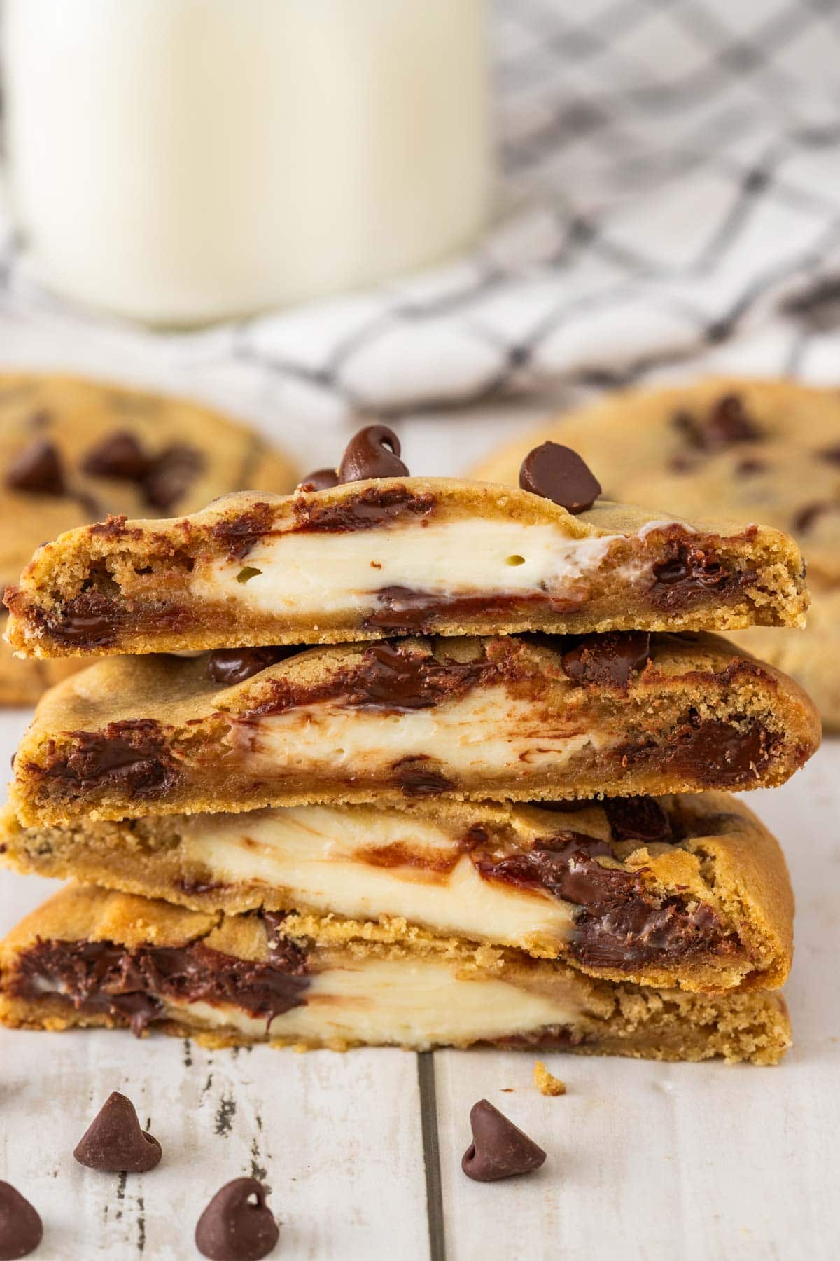 chocolate chip cookies cut in half with a creamy cheesecake interior.