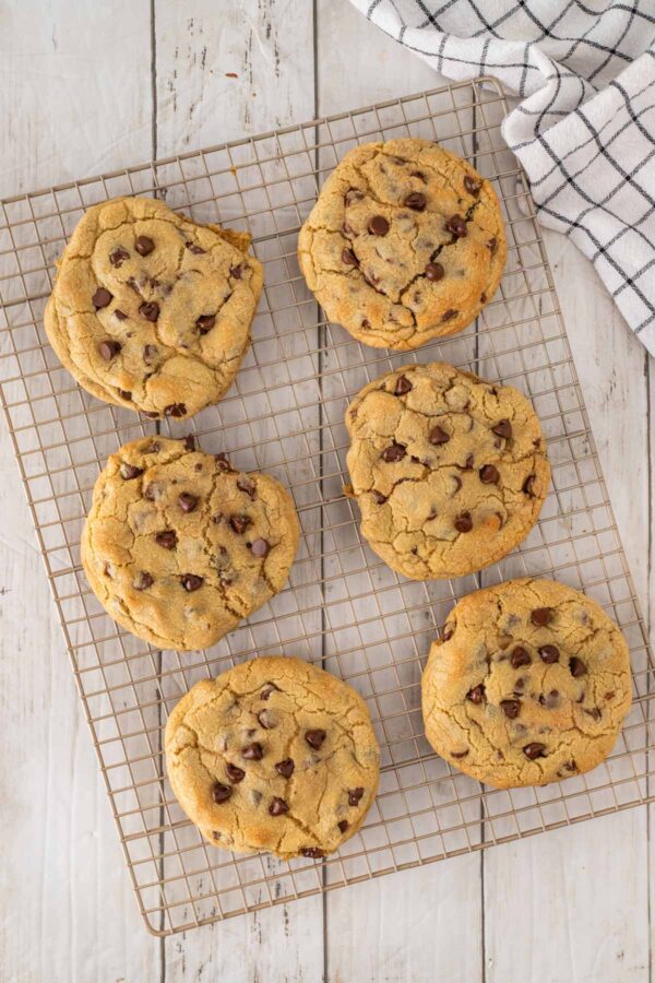 freshly baked cheesecake stuffed chocolate chip cookies on a cooling rack.
