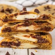 stack of chocolate chip cookies cut open to show the cheesecake interior.